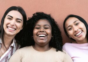 Happy multiracial friends having fun smiling together in front of camera